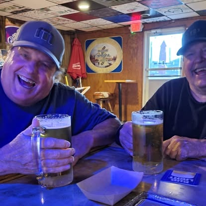 Friends sharing cold mugs of beer at Reggie's